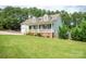 This home is surrounded by lush green trees, a charming front porch, and mature landscaping at 1812 Sam Smith Rd, Fort Mill, SC 29708