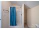 Small shower with a blue curtain and built-in shelving for storage in the bathroom at 1812 Sam Smith Rd, Fort Mill, SC 29708