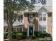 Charming two-story townhouse featuring a brick facade, green shutters, and well-maintained landscaping at 19057 Coachmans Trce, Cornelius, NC 28031