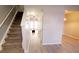 Hallway view leading into a bright living area, complemented by a staircase and neutral color scheme at 19057 Coachmans Trce, Cornelius, NC 28031