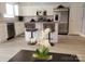 Modern kitchen featuring white cabinets, a breakfast bar, stainless steel appliances, and hardwood flooring at 19057 Coachmans Trce, Cornelius, NC 28031