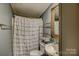 Bathroom featuring a curtained shower, toilet and a sink with a framed mirror at 2006 Kollege Ln, Crouse, NC 28033