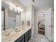 Bathroom boasts a double vanity, large mirror, marble floors, and access to the bedroom at 20132 Tailwind Ln, Cornelius, NC 28031