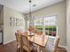 Cozy dining room with wood floors, chandelier, and a bright garden view at 20132 Tailwind Ln, Cornelius, NC 28031