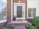 Charming front entryway with a brick facade, decorative plants, and a welcoming front door at 20132 Tailwind Ln, Cornelius, NC 28031