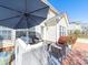 Outdoor patio with comfortable wicker seating, a large umbrella, and a well-manicured yard at 20132 Tailwind Ln, Cornelius, NC 28031