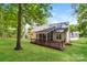 Exterior home view showcases a spacious yard, screened in porch, and a large wooden deck at 2104 Congress Ct, Kannapolis, NC 28083