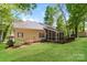 Exterior home view showcases a spacious yard, screened in porch, and a deck at 2104 Congress Ct, Kannapolis, NC 28083