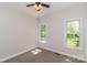 This bedroom features neutral carpeting, ceiling fan, and two windows providing a sunny view of the exterior at 2104 Congress Ct, Kannapolis, NC 28083