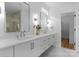 Bright bathroom with double vanity, sleek cabinetry, modern fixtures, large mirrors, and a glass-enclosed shower at 215 Keswick Ave, Charlotte, NC 28206