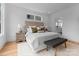 Comfortable bedroom features a neutral color palette, a cozy bench, bedside tables and a window above the headboard at 215 Keswick Ave, Charlotte, NC 28206