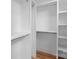 Bright walk-in closet with custom white shelving and wooden floors offers plenty of storage space for clothes at 215 Keswick Ave, Charlotte, NC 28206