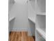 White walk-in closet with custom shelving and wooden floor offers ample storage space for clothes and accessories at 215 Keswick Ave, Charlotte, NC 28206