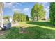 Expansive backyard featuring a lush lawn, mature trees, and a small storage shed at 2409 Deberry Ct, Charlotte, NC 28213