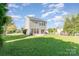 View of the home's exterior and spacious back yard featuring a sliding glass door, grill, and lawn at 2409 Deberry Ct, Charlotte, NC 28213