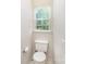Bright half-bathroom with a toilet and window at 2409 Deberry Ct, Charlotte, NC 28213