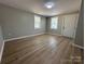 Bright room features new wood-look flooring, neutral paint, two windows and a white door at 312 W Henderson St, Salisbury, NC 28144