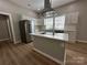 Well-lit kitchen with an island cooktop and stylish stainless-steel refrigerator at 312 W Henderson St, Salisbury, NC 28144