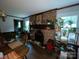 Dining area with a fireplace and view of the kitchen, surrounded by indoor plants at 3452 Odell School Rd, Concord, NC 28027