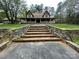 Charming two-story home with brick stairs, a large front porch, and mature trees at 3452 Odell School Rd, Concord, NC 28027