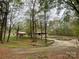 Spacious front yard of a home with mature trees, stone accents, and a covered porch, providing a tranquil setting at 3452 Odell School Rd, Concord, NC 28027