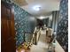 Hallway with floral wallpaper, doors, and stairway with wooden handrail needing tidying at 3452 Odell School Rd, Concord, NC 28027