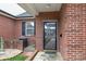 Charming entrance with a secure screen door, classic brick, and a neatly arranged garden area at 3921 Sage Ct, Denver, NC 28037