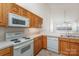 Bright kitchen featuring wood cabinets, white appliances, and views to adjacent room at 3921 Sage Ct, Denver, NC 28037