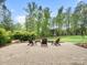 Backyard stone patio features an outdoor seating area with mature trees and a lush lawn at 4012 Flagstone Dr, Lancaster, SC 29720