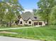 Traditional brick home with a well-manicured front lawn, mature trees, and a circular driveway at 4012 Flagstone Dr, Lancaster, SC 29720