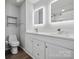 Modern bathroom with dual illuminated mirrors, double sinks, and a glass-enclosed shower at 4211 Center Place Dr, Harrisburg, NC 28075