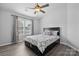 Comfortable bedroom featuring wood floors, a ceiling fan, and a cozy bed with bedside window at 4211 Center Place Dr, Harrisburg, NC 28075