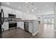 Modern kitchen featuring stainless steel appliances, granite countertops and a view of the living room at 4211 Center Place Dr, Harrisburg, NC 28075