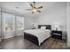 Cozy bedroom with a ceiling fan, hardwood floors, and a large window at 4211 Center Place Dr, Harrisburg, NC 28075