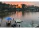 Picturesque lake view featuring a dock, outdoor furniture, and a sunset sky at 428 Pinehaven Dr, New London, NC 28127