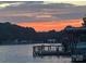 Waterfront view featuring boat dock and lake with a colorful sunset reflecting on the water at 428 Pinehaven Dr, New London, NC 28127