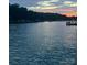 Sunset view of the lake, with trees in the background, and the water shimmering in the foreground at 428 Pinehaven Dr, New London, NC 28127