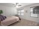 Clean and well-lit bedroom with a large window, ceiling fan, and neutral carpeting at 5109 Arbordale Way, Mount Holly, NC 28120