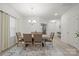 Dining room with wood table and chairs, modern chandelier, and neutral rug at 5109 Arbordale Way, Mount Holly, NC 28120