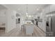 Open kitchen with island, white cabinets, granite countertops, and stainless steel appliances at 5109 Arbordale Way, Mount Holly, NC 28120