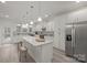 A kitchen featuring a large island with wooden stools and stainless steel appliances at 5109 Arbordale Way, Mount Holly, NC 28120