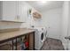 Functional laundry room featuring modern washer/dryer, storage cabinets, and countertop for folding at 5109 Arbordale Way, Mount Holly, NC 28120
