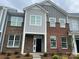 Front exterior of townhome with brick facade, gray siding, and black front door at 534 Dorman St, Belmont, NC 28012