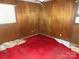 Cozy room featuring wood paneling, carpeted floors, and natural light from the window at 543 Queens Rd, Gastonia, NC 28052