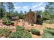 Inviting backyard features a fire pit, patio seating, and lush landscaping around the home and separate structure at 6010 Hawk View Rd, Waxhaw, NC 28173