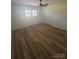 Cozy bedroom boasts hardwood floors, natural light, and a ceiling fan at 6372 Morehead St, Harrisburg, NC 28075