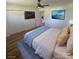 This bedroom features a ceiling fan, large television, and cozy blue and tan decor at 6372 Morehead St, Harrisburg, NC 28075