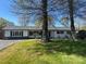 Charming single story home with a well-manicured lawn and mature trees on a sunny day at 6372 Morehead St, Harrisburg, NC 28075