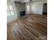 Spacious living room featuring gleaming hardwood floors, abundant natural light, and a cozy fireplace at 6372 Morehead St, Harrisburg, NC 28075