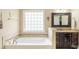 Bright bathroom featuring a large tub and neutral toned tile at 641 Weyburn Nw Dr, Concord, NC 28027